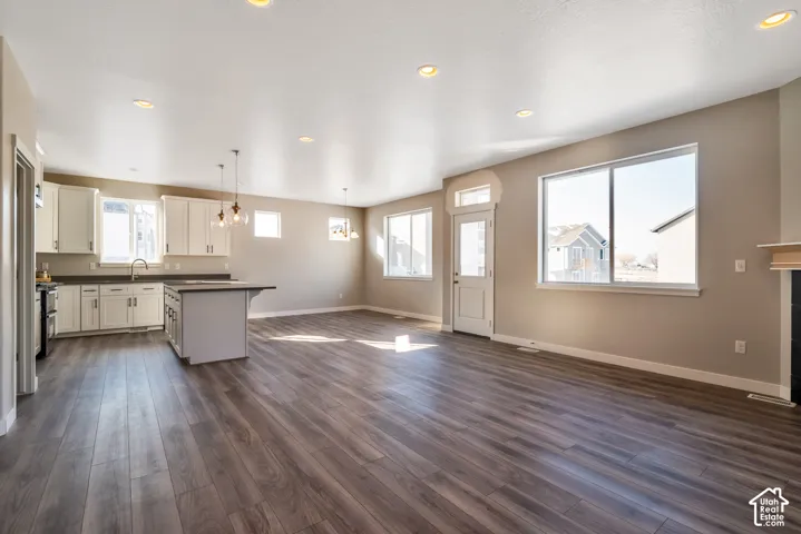 Open-concept living area featuring wood-finish flooring, recessed lighting, and ample natural light through multiple windows
