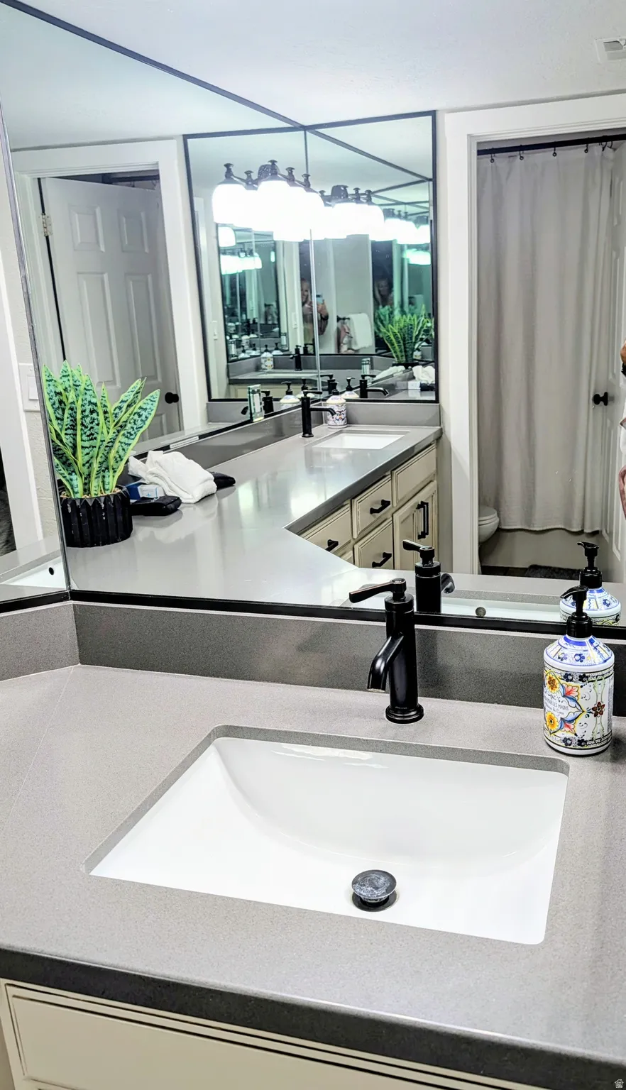 Modern bathroom vanity featuring a rectangular undermount sink, light quartz countertop, and matte black wall-mounted faucet
