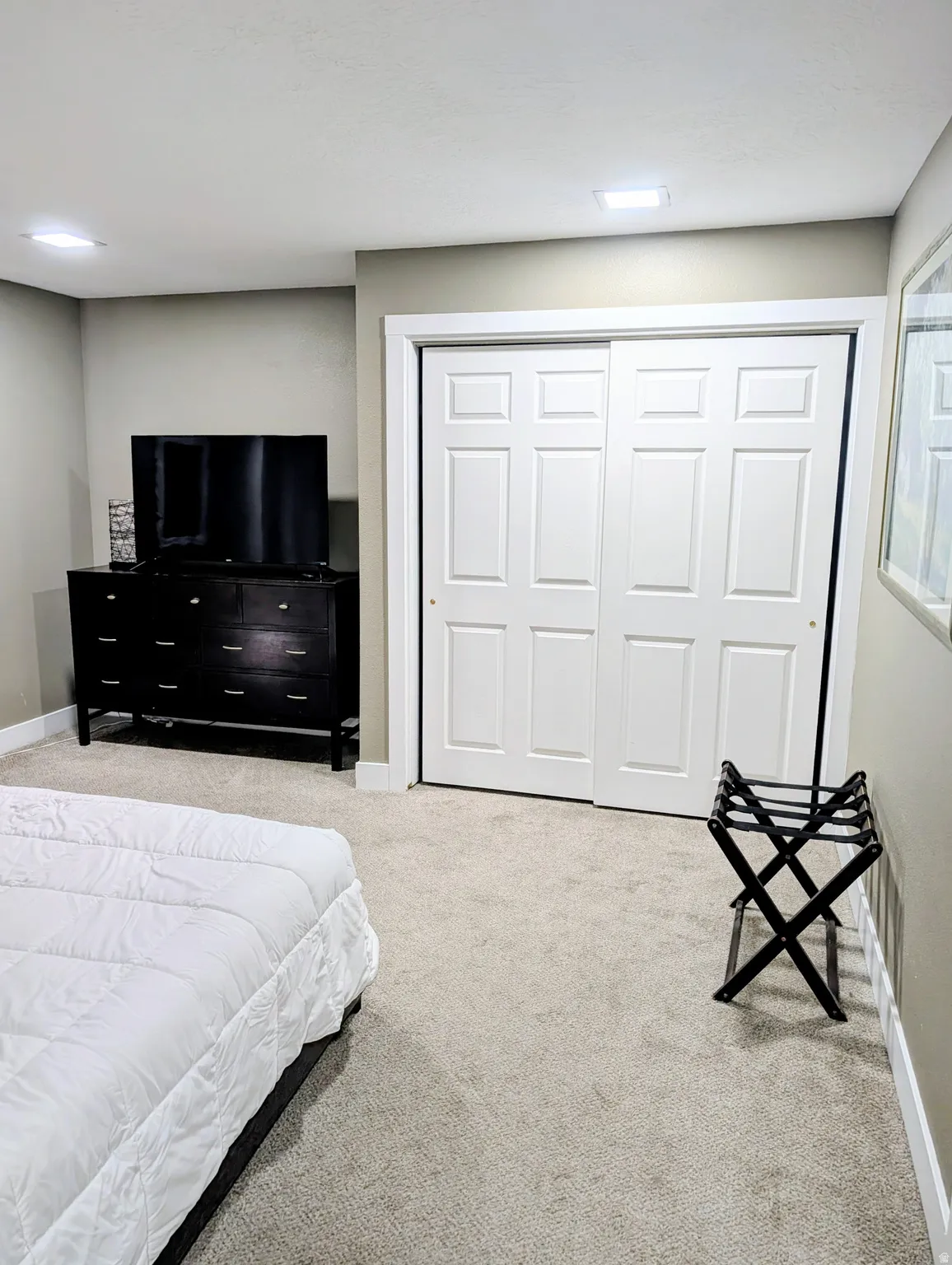 Wall-to-wall carpeting with white trim, recessed square lighting, and white sliding closet doors