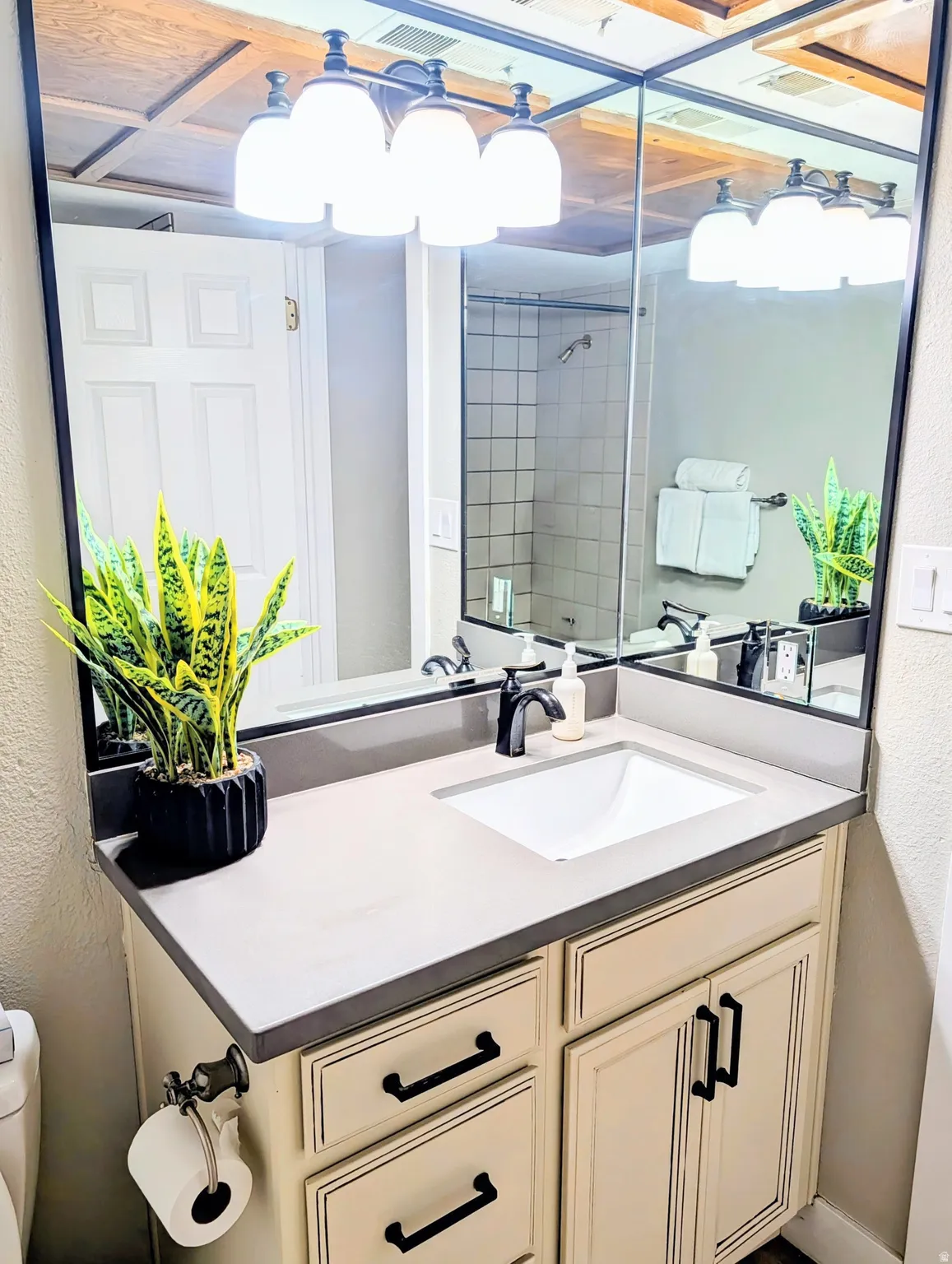 Vanity with integrated sink, dark countertop, and matte black faucet
