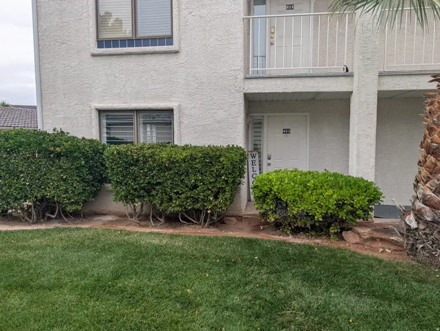 Stucco exterior featuring multiple windows with horizontal blinds