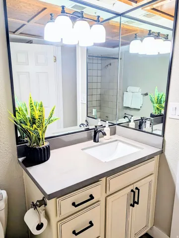 Vanity with integrated sink, dark countertop, and matte black faucet