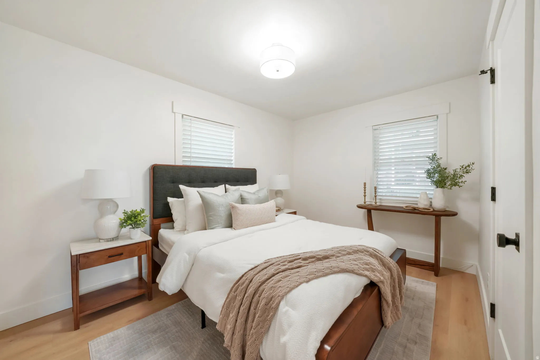 Wood-finish flooring, white walls, and a contemporary ceiling light fixture