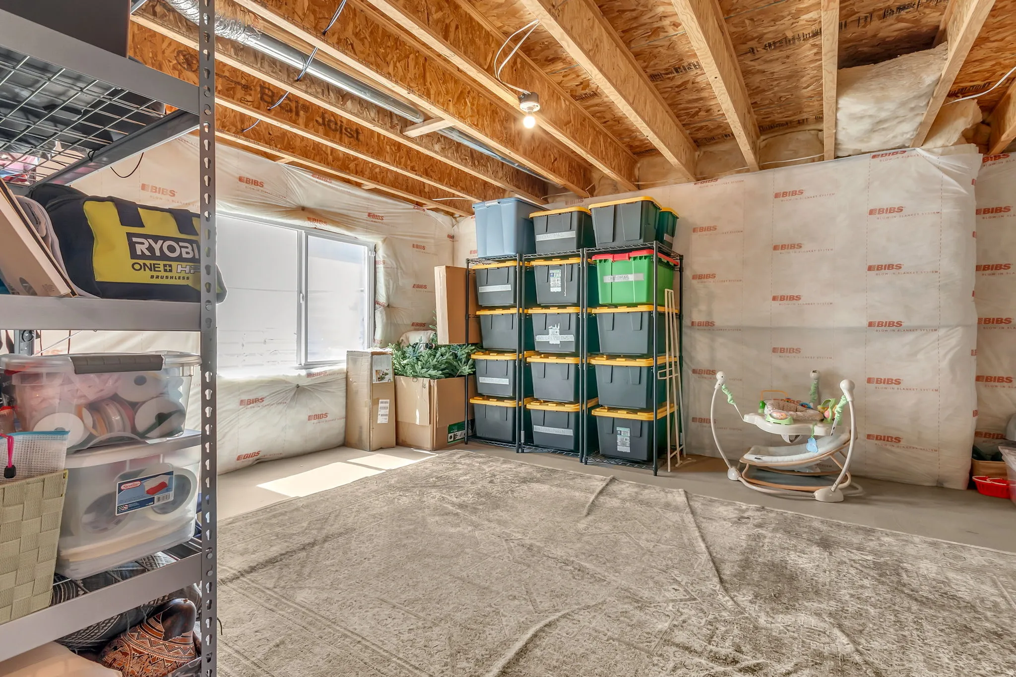 Unfinished basement space featuring exposed wood joists and a single window