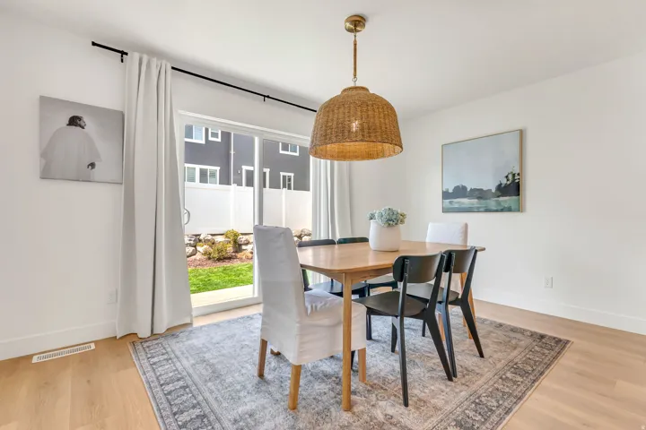 Dining area featuring light wood-finish flooring and a contemporary woven pendant light fixture