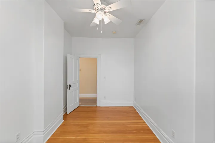 Room featuring hardwood flooring and a ceiling fan with integrated lighting
