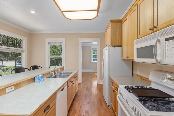 Kitchen featuring wood-finish flooring, light-toned cabinetry, and white countertops
