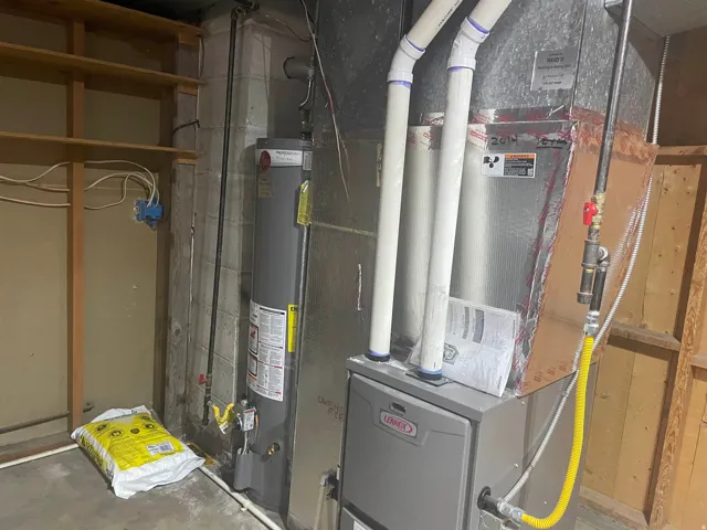 Lennox furnace and water heater installation featuring exposed ductwork and block wall construction