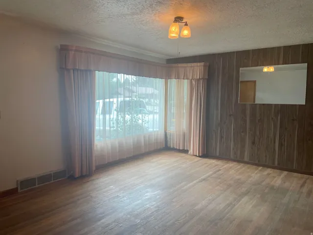 Hardwood-finish flooring complementing a wood-paneled accent wall