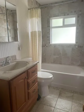 Bathroom featuring a wood-finish vanity with an integrated sink and chrome faucet