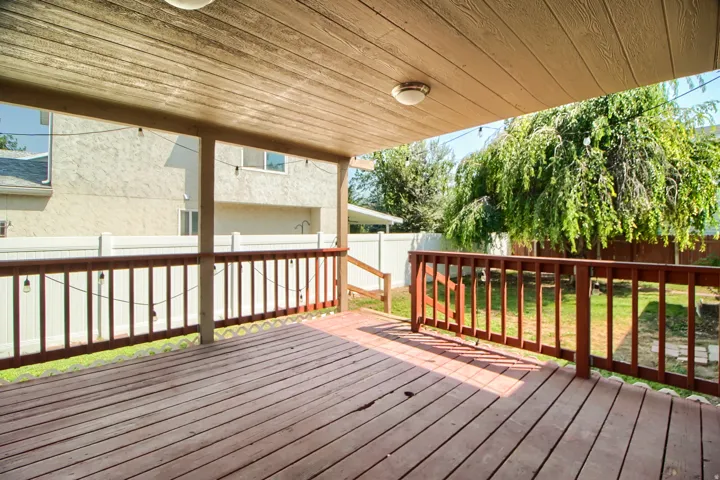 Expansive covered deck featuring wood decking and a wooden railing