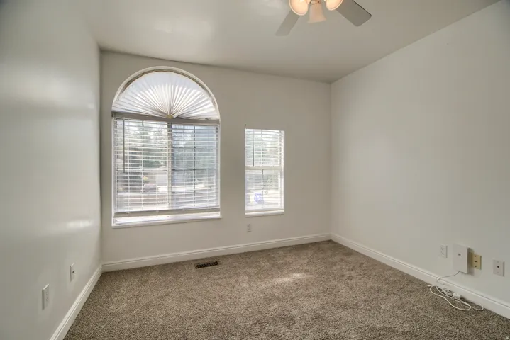 Bright corner bedroom with arched transom window and secondary window providing natural light