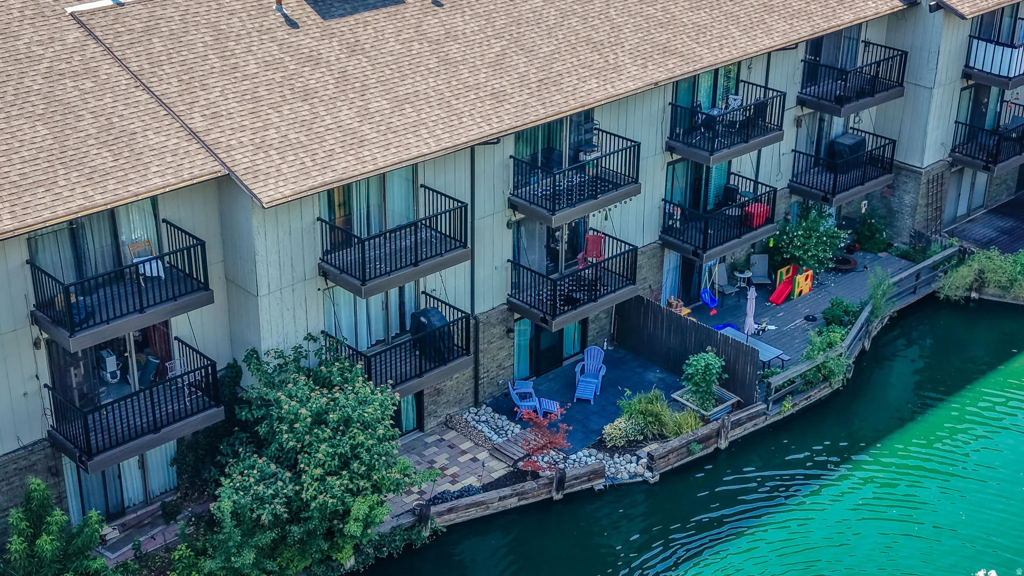 Waterfront property with multiple balconies, a lower-level patio, and an upper deck