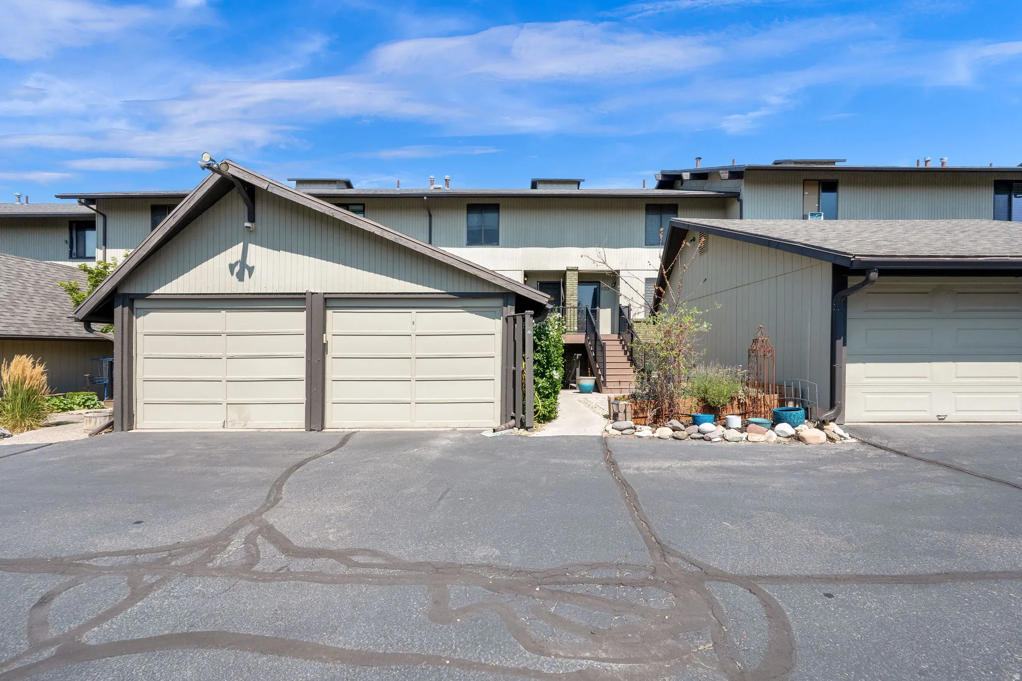 Attached garages with panel doors, and neutral-toned siding