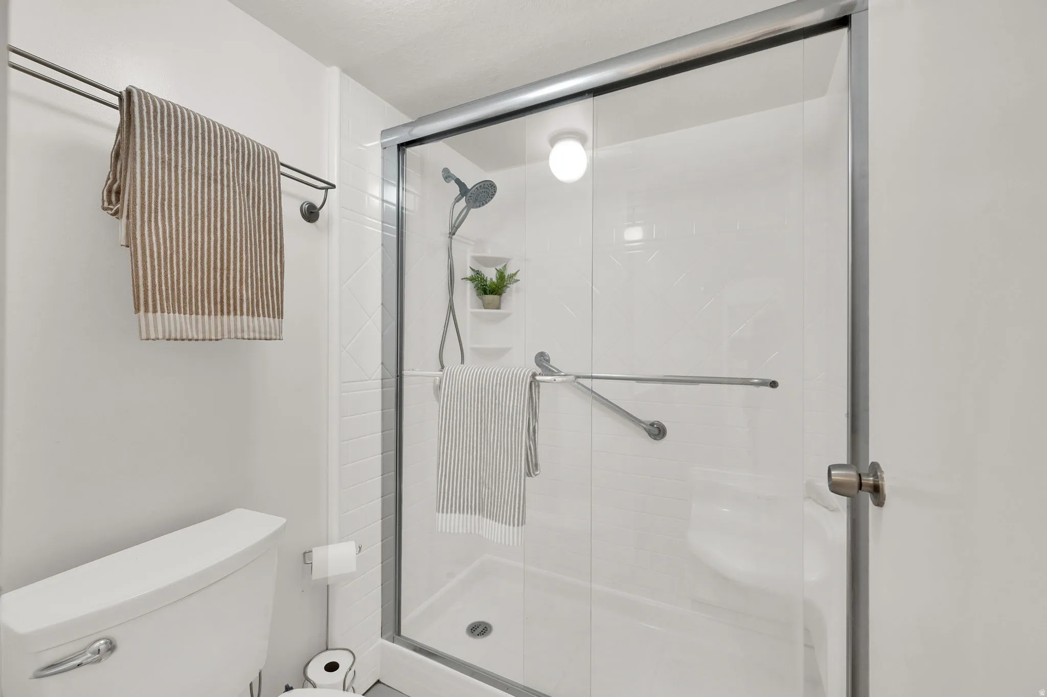Walk-in shower with clear glass enclosure and chrome framing