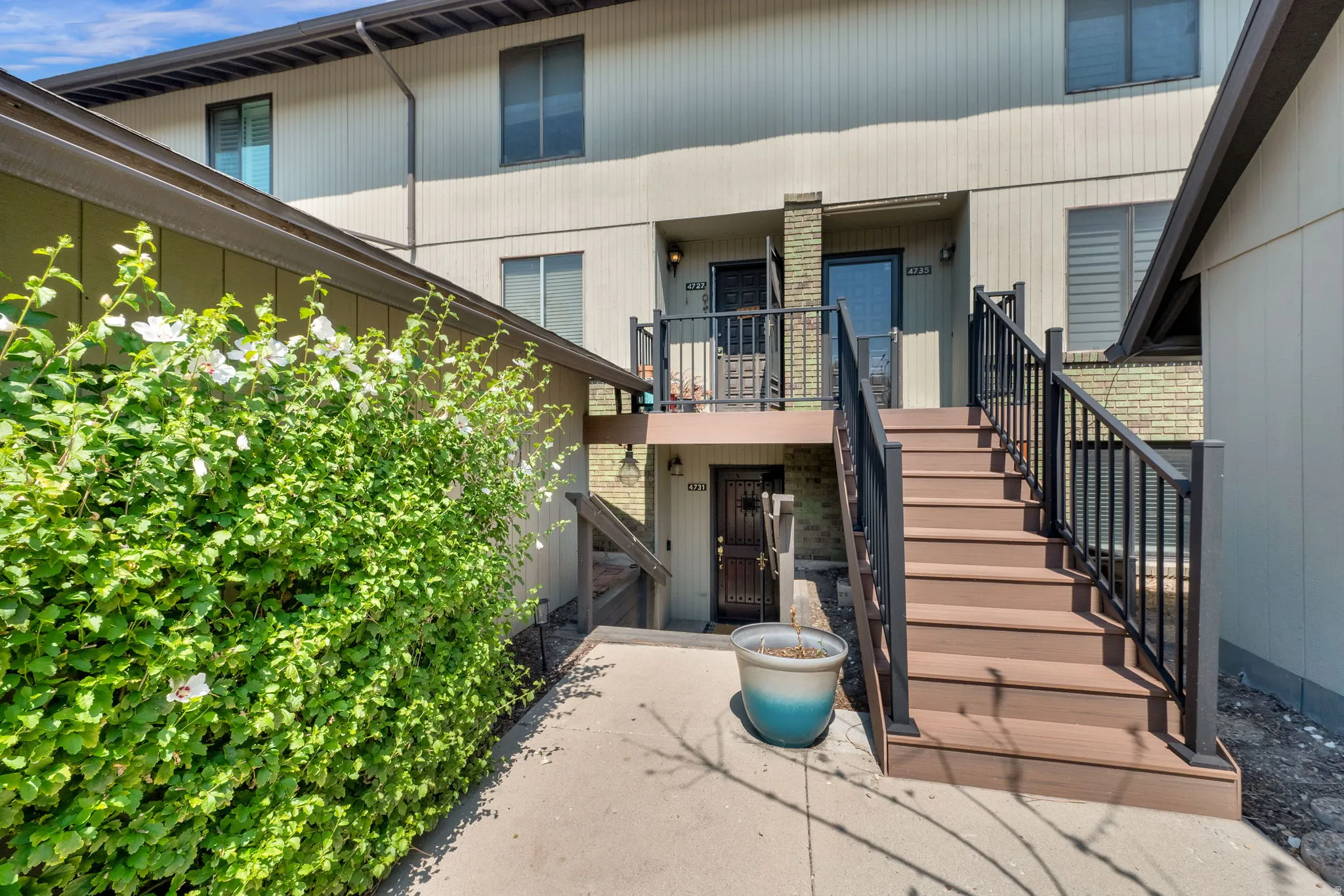 Multi-level exterior with composite decking stairs and black metal railings