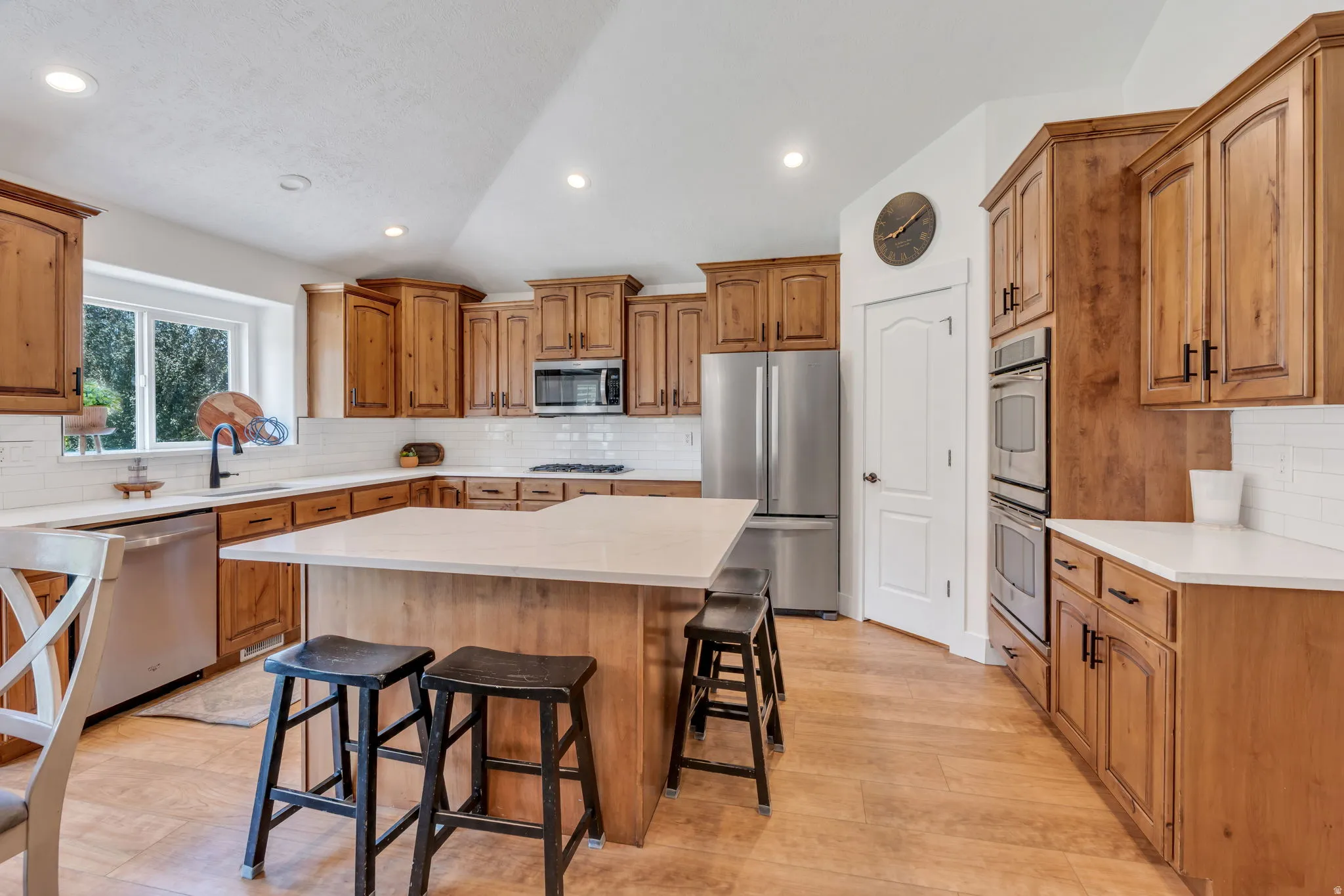 Gourmet kitchen featuring custom wood cabinetry, stainless steel appliances, and a large center island with seating