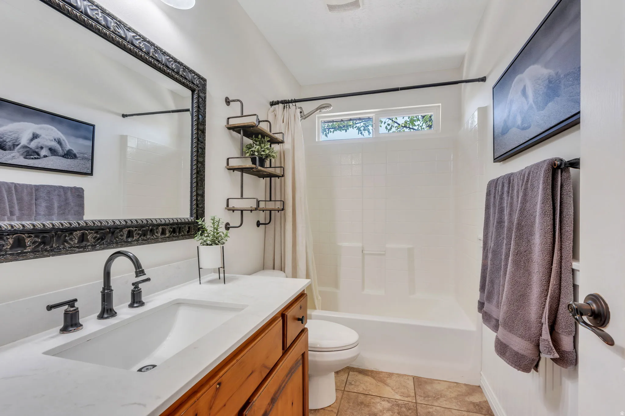 Bathroom featuring a vanity with an integrated rectangular sink, a black faucet, and a large ornate framed mirror