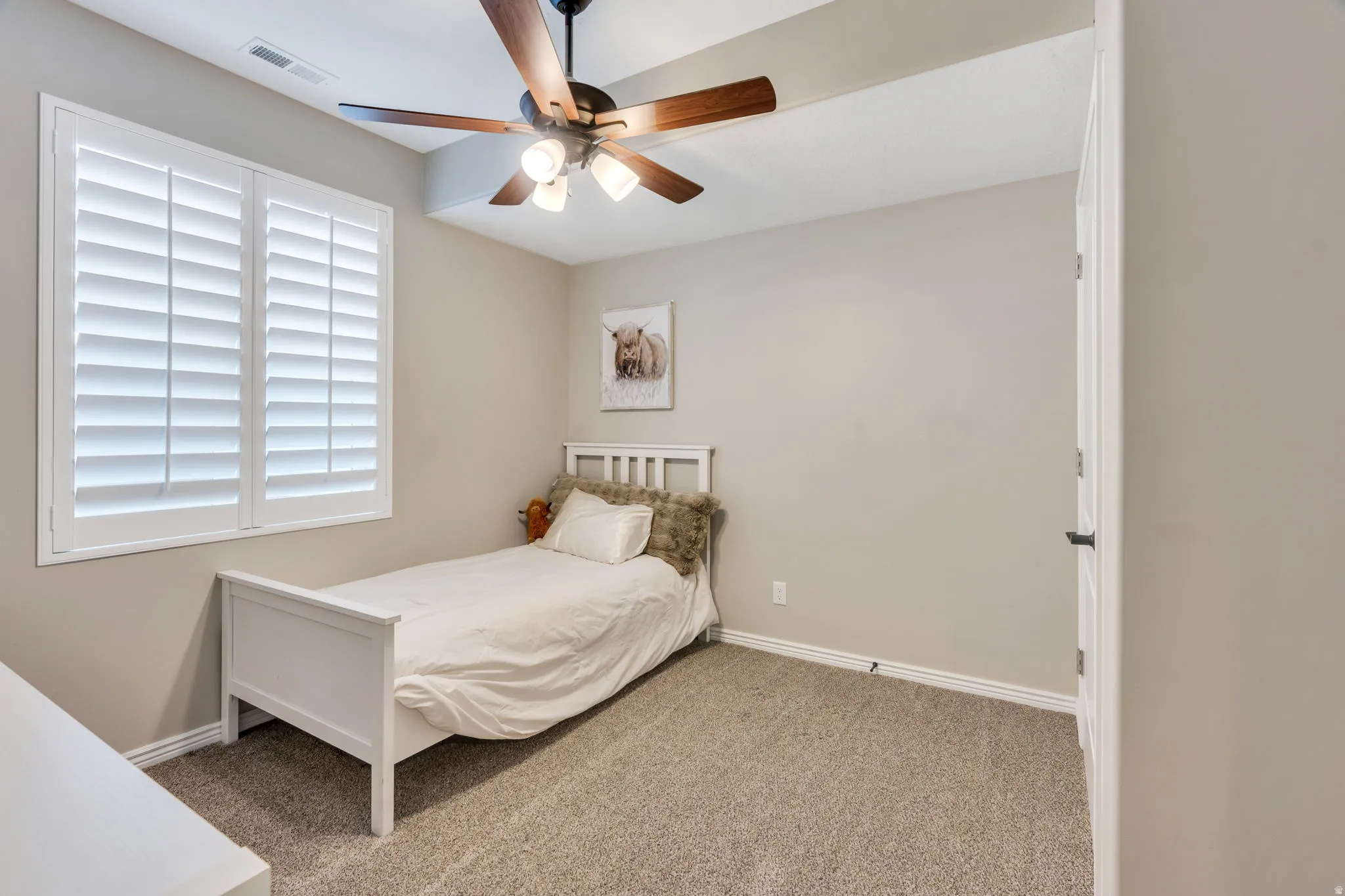 Bedroom featuring neutral-toned carpet, light gray wall paint, and white trim
