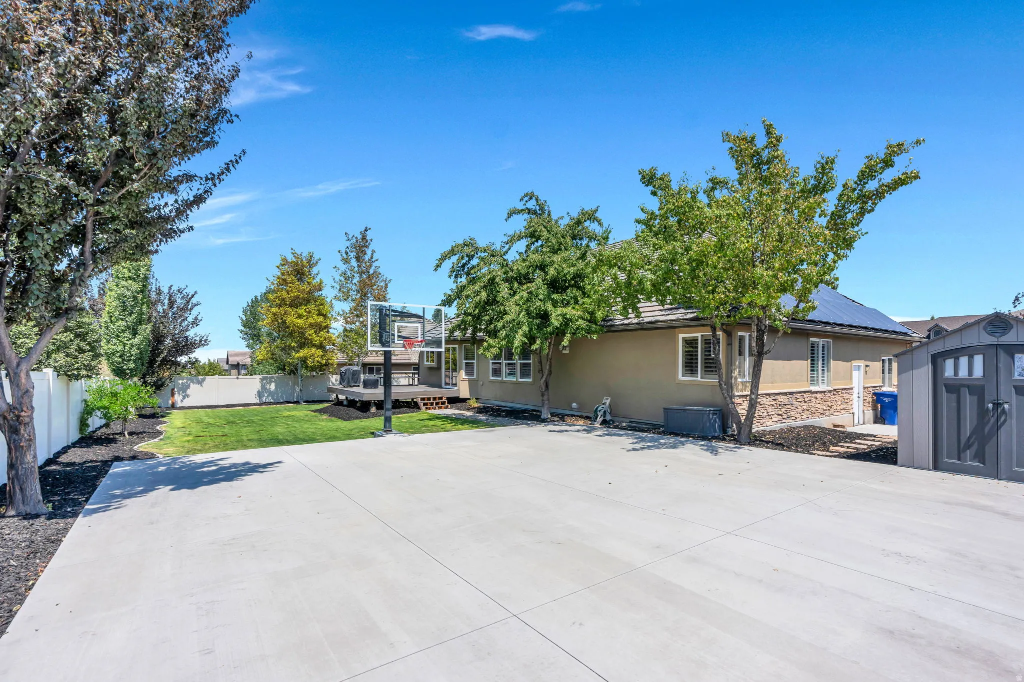 Spacious concrete pad ideal for recreation, featuring a basketball hoop