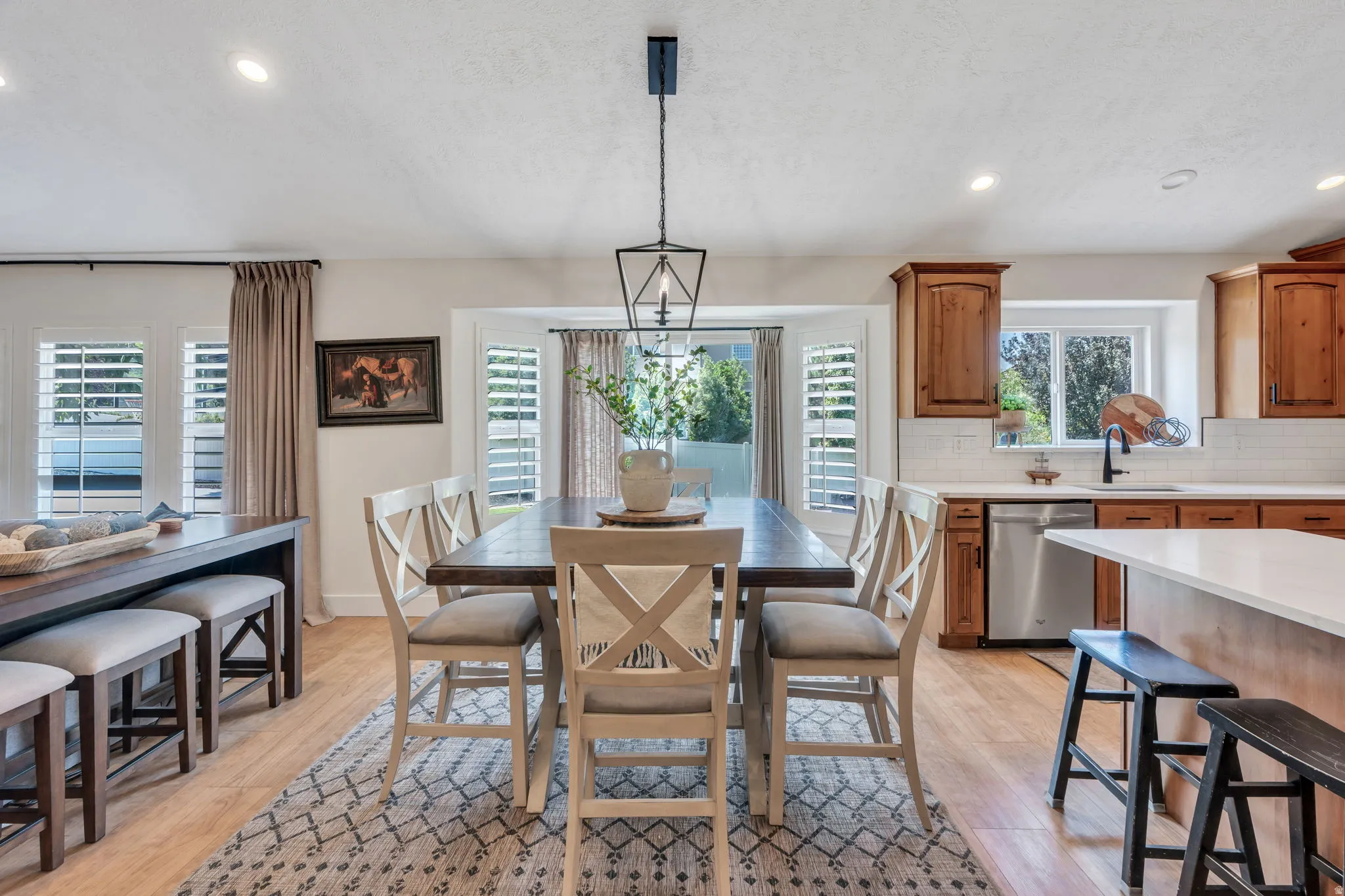 Open-concept living space featuring wood-finish flooring, recessed lighting, and a contemporary lantern pendant light fixture