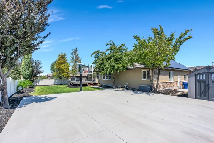 Spacious concrete pad ideal for recreation, featuring a basketball hoop