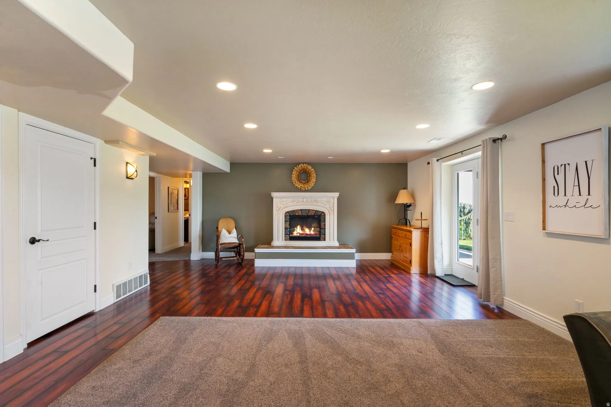 Recessed lighting, white trim, and a fireplace with an ornate white mantel and hearth