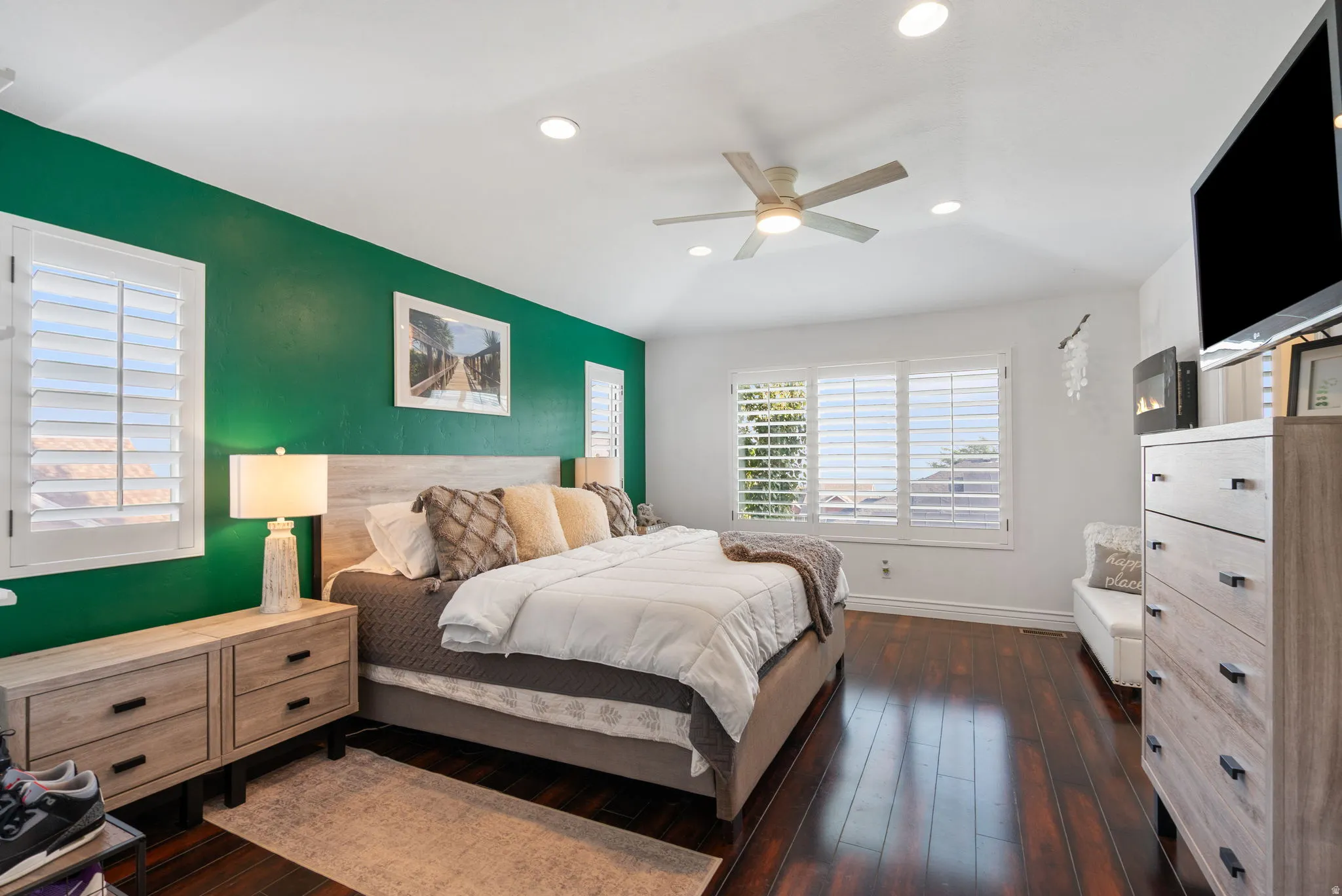 Dark wood-finish flooring with white baseboards, recessed lighting, and a ceiling fan