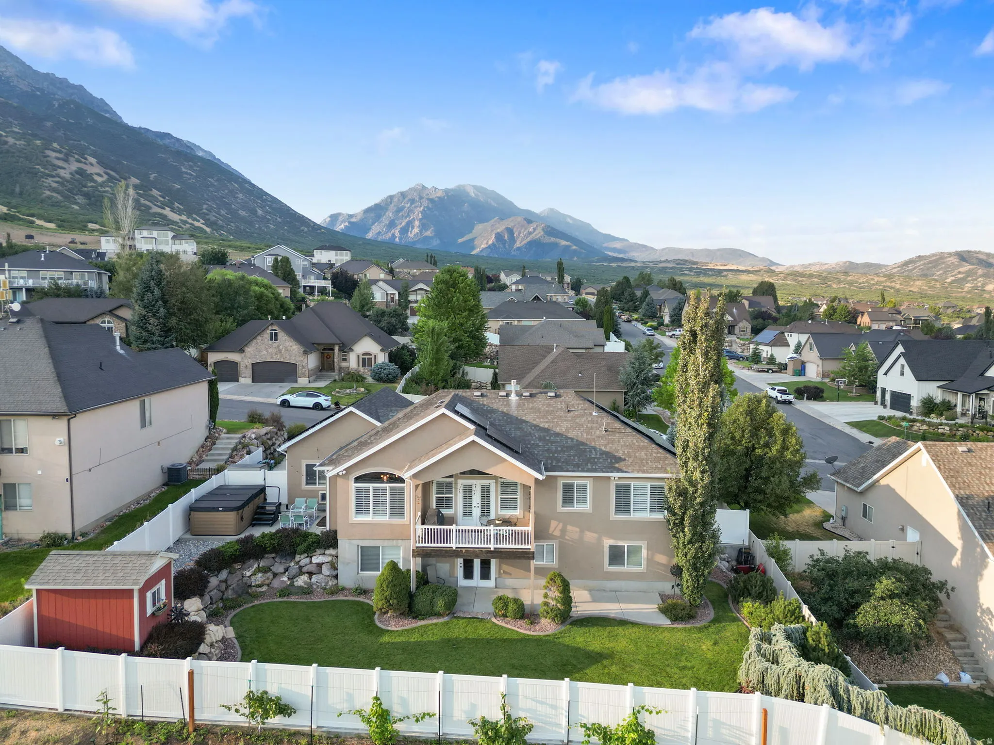 Elegant two-story residence featuring a cream-colored exterior with multi-pane windows and architectural detailing
