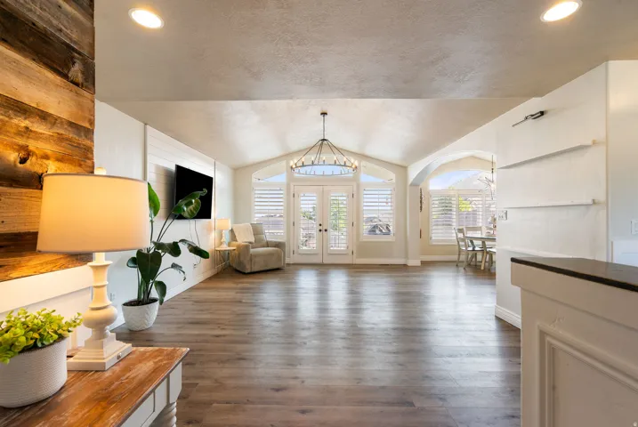 Elegant foyer showcasing soaring ceilings with recessed lighting, wide-plank wood-finish flooring, and arched architectural details