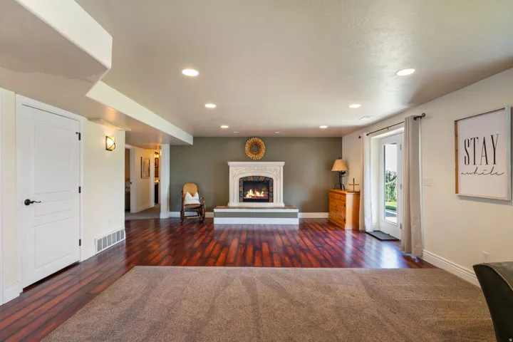 Recessed lighting, white trim, and a fireplace with an ornate white mantel and hearth