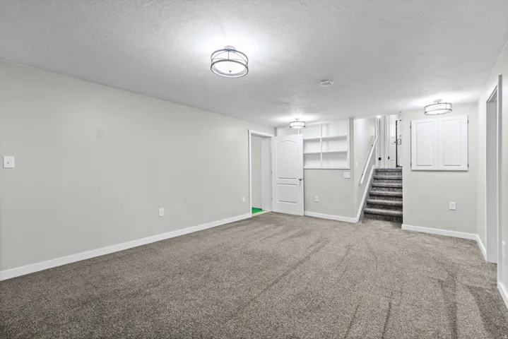 Spacious room with gray carpeting and light gray walls