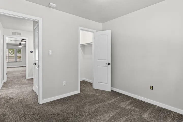 Plush carpet flooring, white trim, solid core doors, and a built-in closet with shelving
