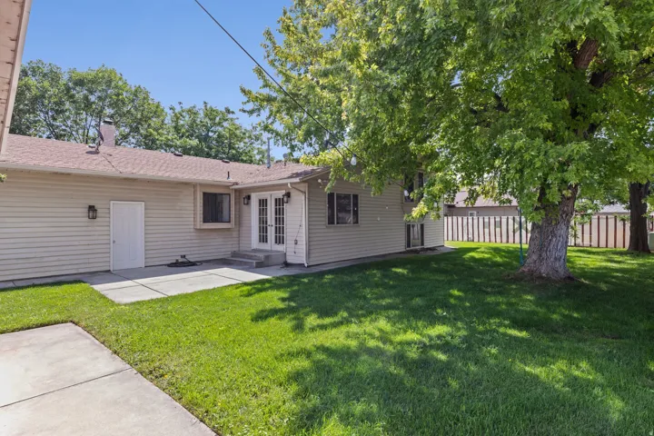 Charming ranch-style home with a sprawling backyard featuring mature shade trees and lush lawn