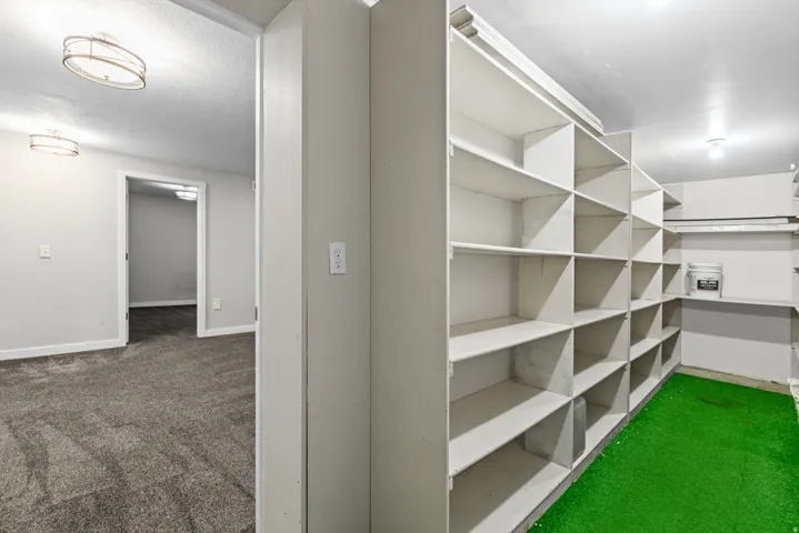 Spacious walk-in closet featuring custom built-in shelving with multiple compartments and cubbies, recessed lighting, and carpet flooring