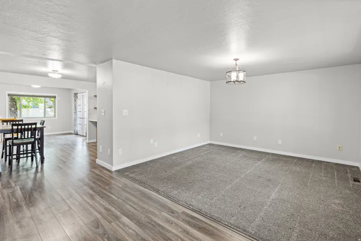 Spacious living area featuring wood-finish flooring throughout, neutral wall finishes, and recessed lighting