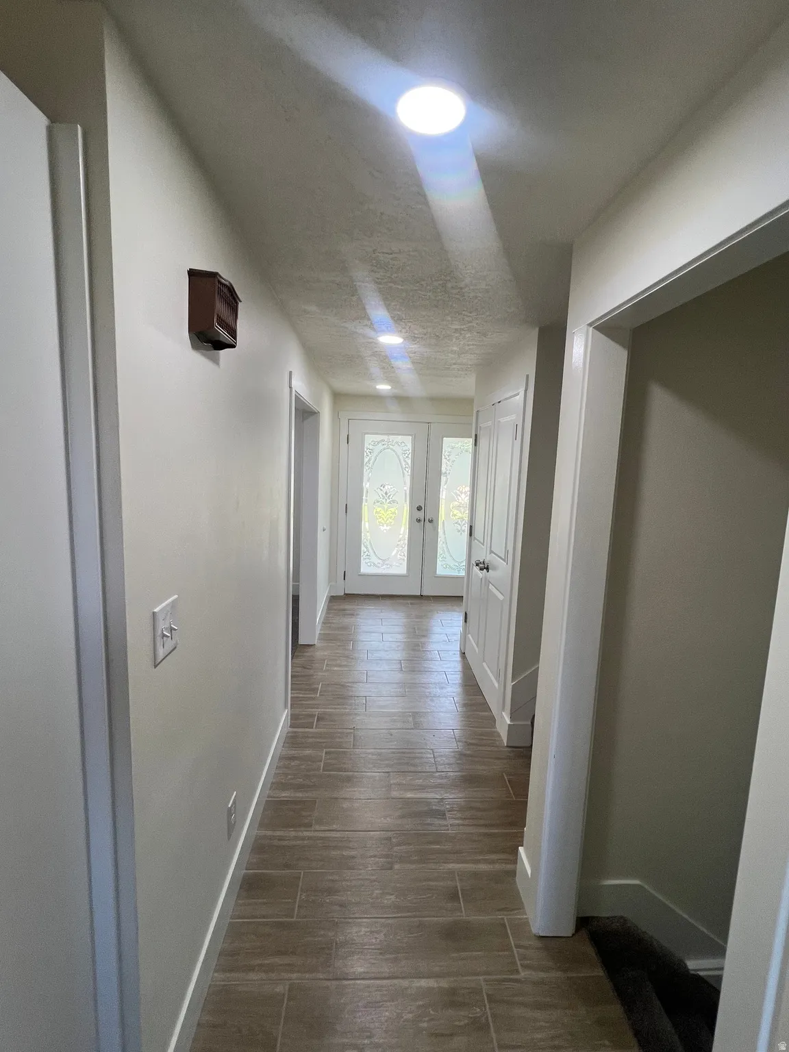 Hallway featuring tile flooring, recessed lighting, and white trim
