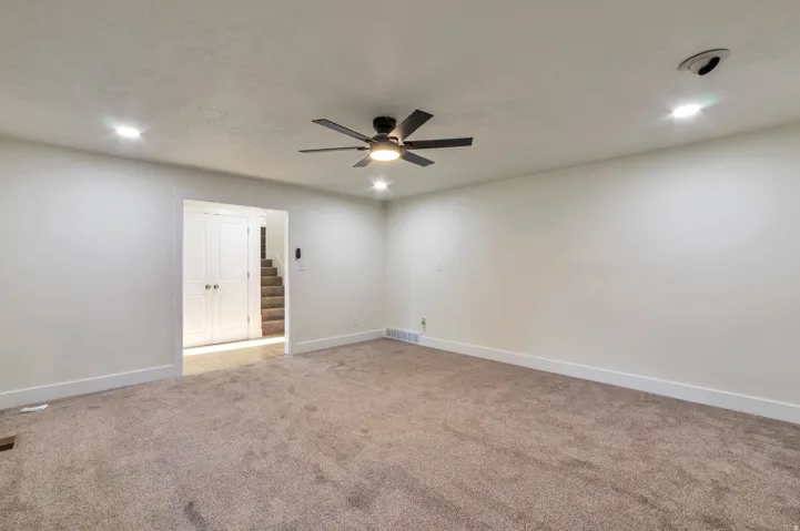 Recessed lighting, ceiling fan with integrated light, light-toned carpeting, white walls, and white trim