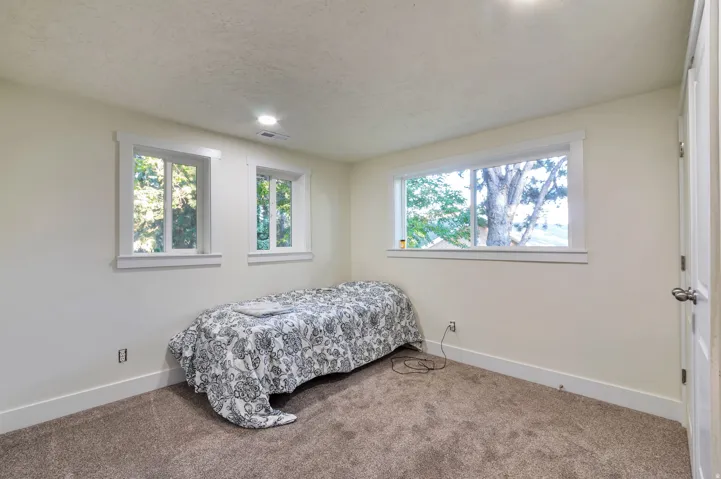 Neutral-toned carpeting, white trim, recessed lighting, and a white paneled door