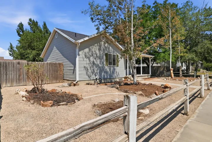 Light gray vinyl siding exterior with a dark shingle roof, featuring a gable architectural element