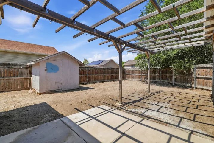 Expansive backyard featuring a wood pergola and concrete patio