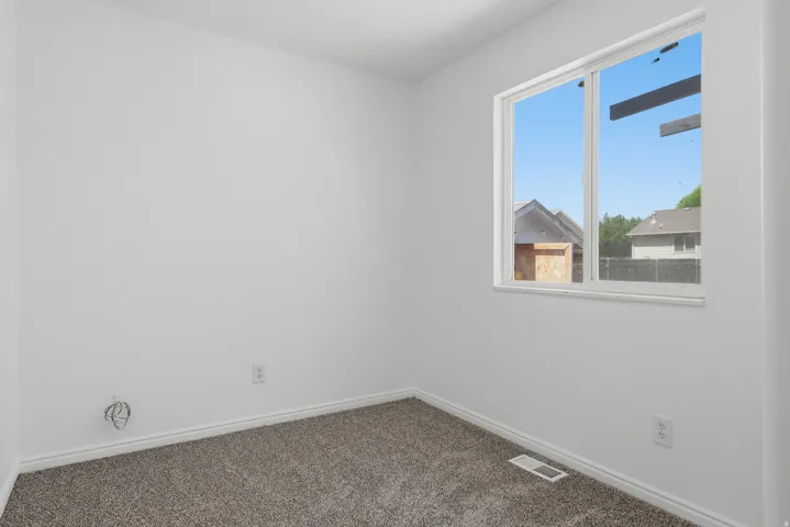 White interior walls with neutral carpet flooring and white baseboards