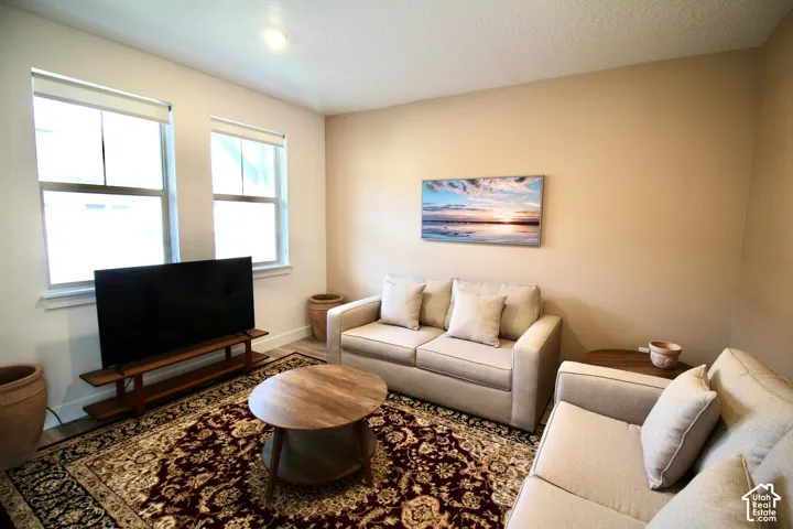 Living area featuring dual windows, recessed lighting, and wood-finish flooring