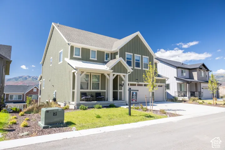 Two-story exterior featuring vertical siding, a covered front porch with timber-frame accents, a multi-car garage, and a mountain backdrop