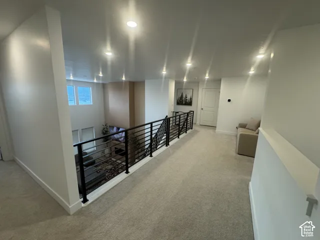 Upper-level hallway with light-toned carpeting and recessed lighting