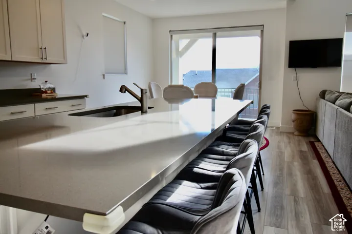 Kitchen island with an undermount sink, a gooseneck faucet, and seating for multiple individuals