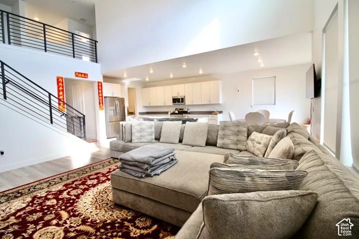 Open-concept living area featuring a vaulted ceiling and light wood-finish flooring