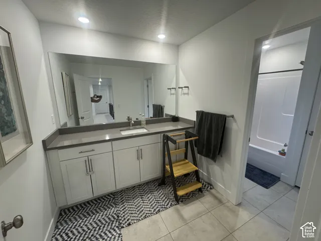Bathroom featuring a white vanity with extensive counter space and a single undermount sink