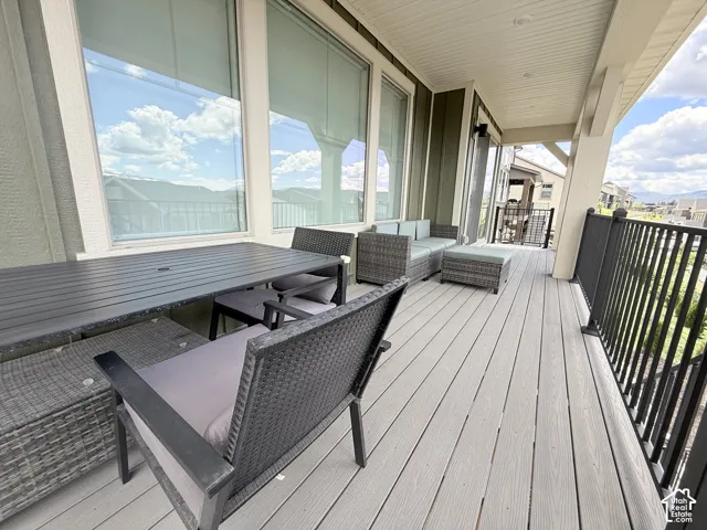 Spacious covered deck featuring composite decking, white ceiling, and exterior lighting