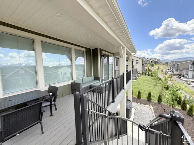 Expansive private deck featuring composite decking, black metal railings, and a covered ceiling